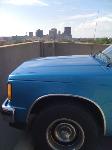 the blue bomber parked up on a roof, downtown dayton in the background.